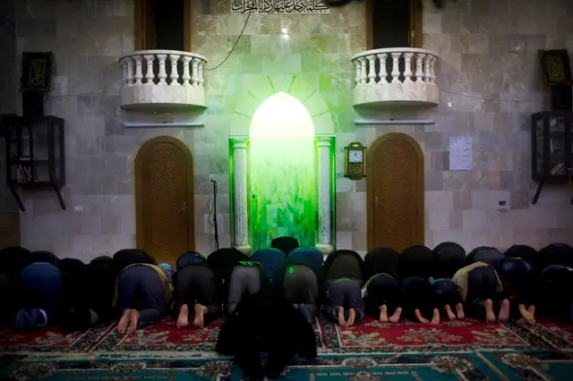 De mange muslimer i lejren beder i den lokale moske.